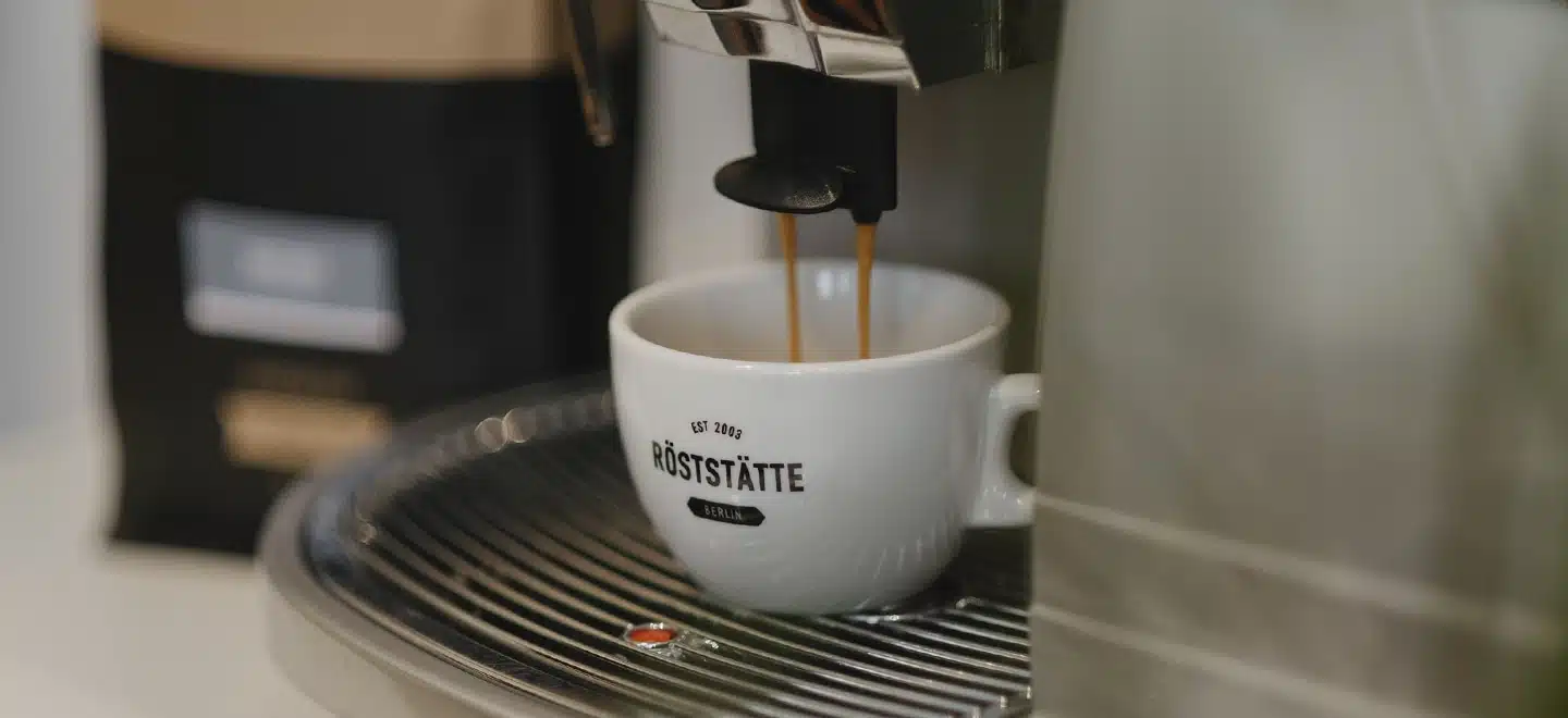 Kaffee aus dem Vollautomaten: Kaffee läuft von der Maschine in einer Tasse.